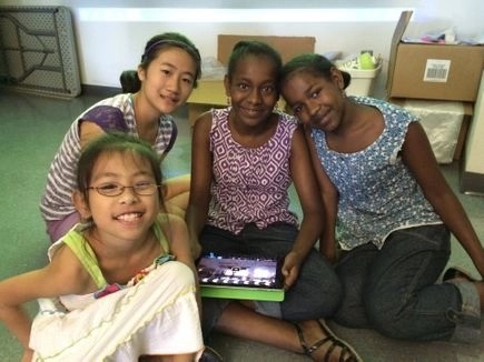 four campers smiling with tablet