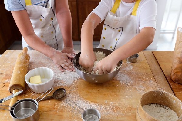 kids hands mixing dough in a bowl