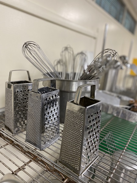graters and wire whisks on a shelf