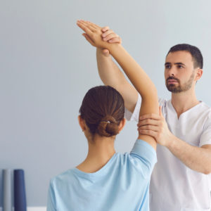 health care practitioner stretching a patient's arm