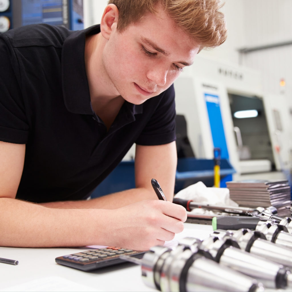 student at a desk with pen in hand