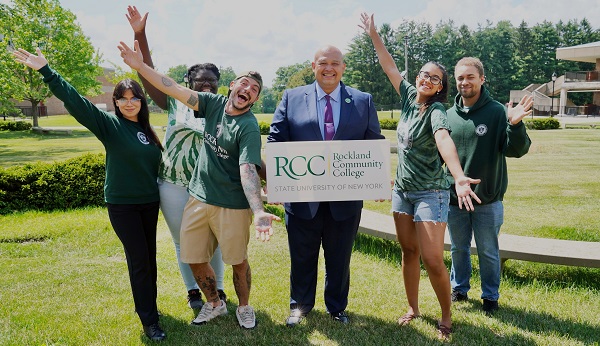 Dr. Rápalo holding RCC sign with student group