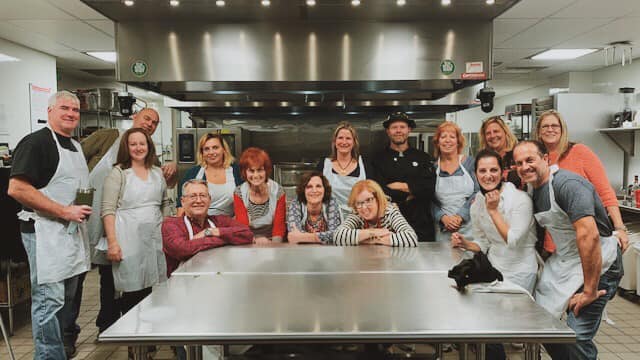 group of attendees around prep table at food enthusiast class