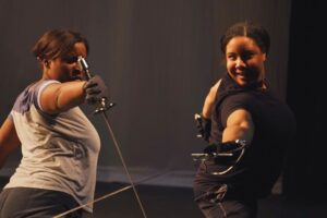 students participating in theatrical stage combat with swords