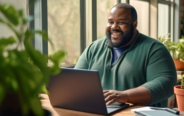 man smiling looking at a laptop