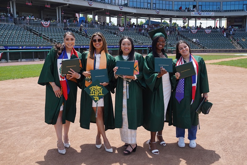 five graduating students on the field at commencement