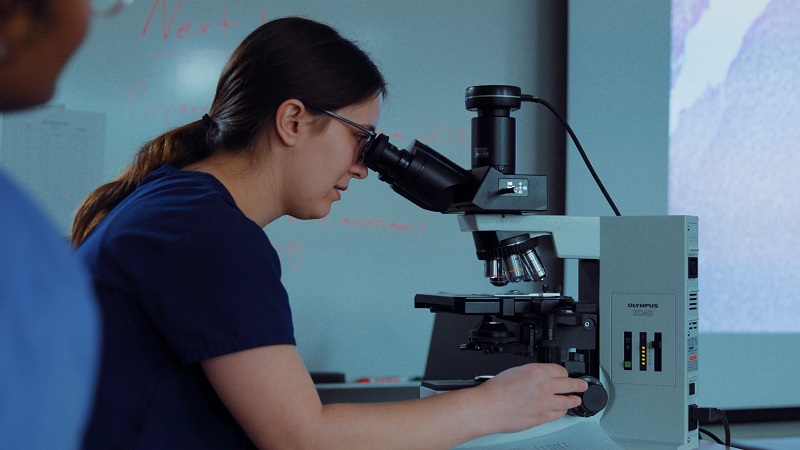 student looking through microscope