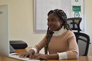 student sitting at a keyboard looking at computer screen