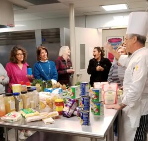 group with chef around prep table at food enthusiast class