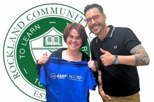 one person holding blue ASAP RCC shirt and another giving thumbs up