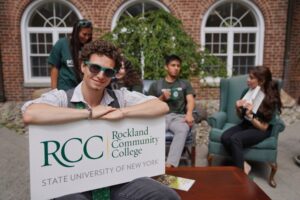 students outside with one holding RCC sign