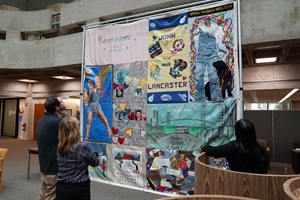 people looking at AIDS quilt on display in the library