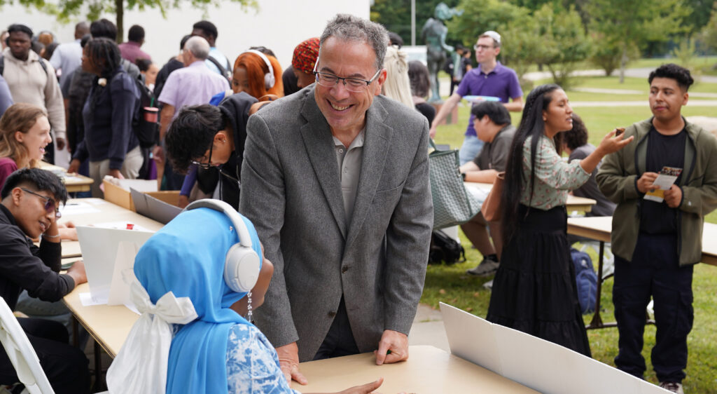Rockland Community College President William P. Mullaney speaking laughing with a student.